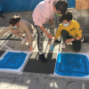 Niños pintan pictogramas en un paso de cebra.