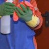 Persona limpiando con guantes y lejía