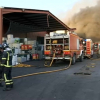 Bomberos trabajan en la extinción del incendio declarado en la planta de Lobón