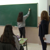 Clase de secundaria con panel con bolsillos para moviles.