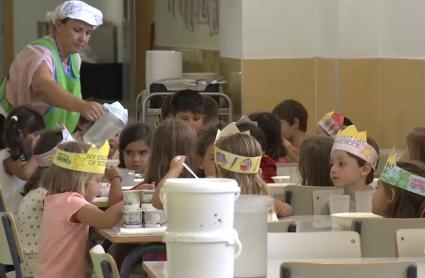 Una persona sirve agua en un comedor escolar