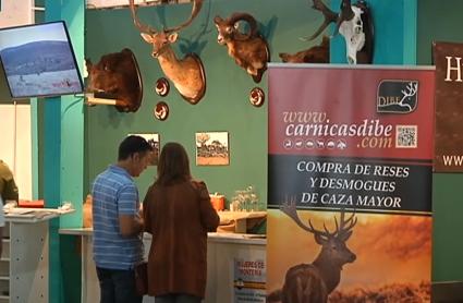 Stand de la Feria de la Caza, la Pesca y la Naturaleza Ibérica, con público y cabezas de animales. 