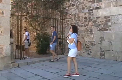 Una turista se acerca a la puerta de acceso a la Torre de Bujaco de Cáceres