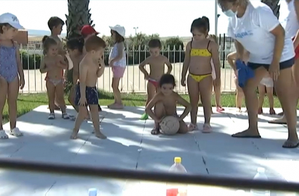 Niños pequeños jugando a los bolos en bañador