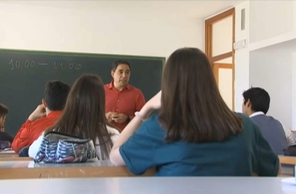 Niños y niñas en clase atendiendo a las explicaciones del profesor