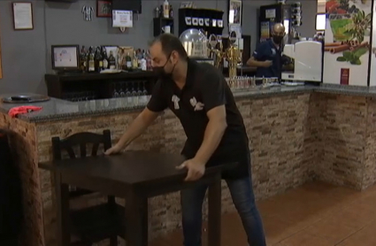Un trabajador prepara su bar para las nuevas restricciones