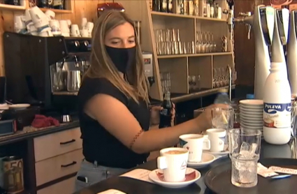 Según el último informe del Observatorio de Emancipación Joven de España, la población juvenil tiene con el coronavirus menos posibilidades de independizarse. Un camarera joven prepara varios cafés en la barra de un bar.