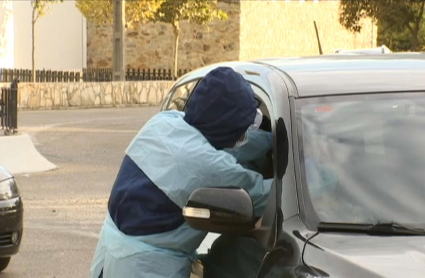 Un profesional sanitario realiza una prueba pcr en un vehículo