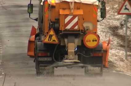 Máquina esparciendo sal contra el hielo en la carretera