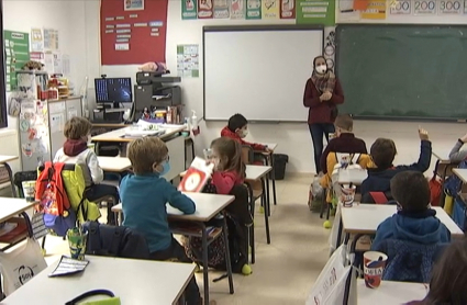 Alumnos de Primaria del colegio Castra Caecilia de Cáceres en su regreso hoy a las aulas. Imagen del interior de un aula con alumnos en sus pupitres y su profesora al pie de la pizarra.