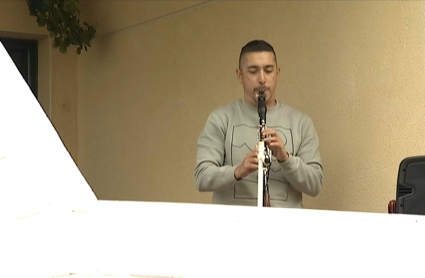 Extremeño tocando el clarinete desde su balcón durante el confinamiento. 