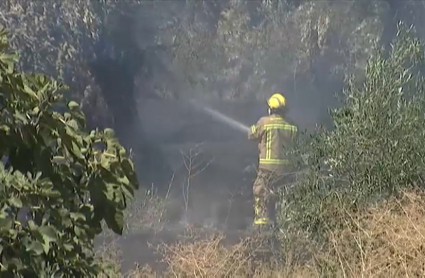 Bombero apagando incendio con una manguera