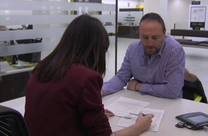 Un cliente contratando un préstamo hipotecario en una sucursal bancaria.